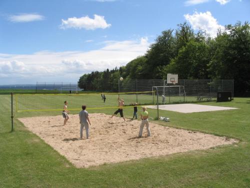 a group of people playing a game of volleyball in a field at Ostseeferienpark Walkyrien - Bootsmann 11 in Schashagen
