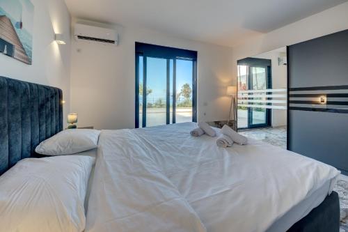 a bedroom with a bed with two stuffed animals on it at Sea Salt Apartment in Kruče