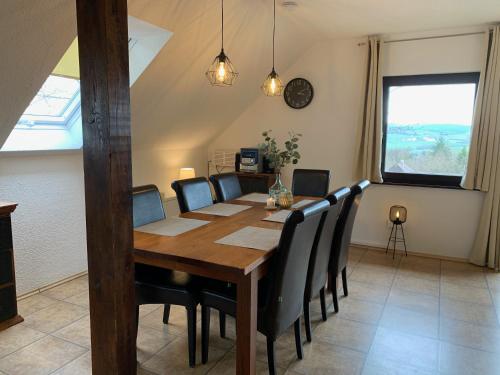a dining room with a wooden table and chairs at Ferienwohnung Lix direkt am Waldrand in Frankenau
