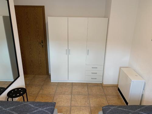 a bedroom with a white cabinet and a tiled floor at Ferienwohnung Lix direkt am Waldrand in Frankenau