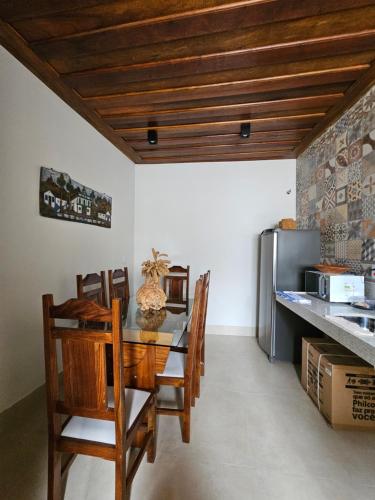 a dining room with a table and chairs and a refrigerator at Vesperata Diamantina in Diamantina