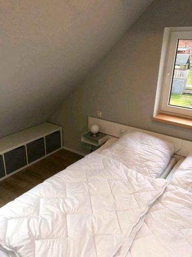 a large white bed in a room with a window at Ferienwohnung am Storchnest in Kenz