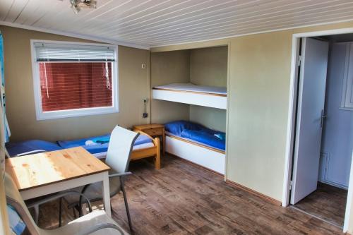 a small room with a bunk bed and a table at Finnenhaus 1 in Lübeck