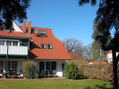 a house with an orange roof with tables and chairs at Kormoran Muschelsucher in Prerow