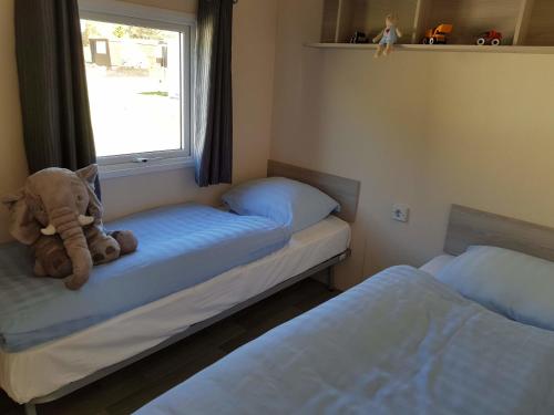 a teddy bear sitting on a bed in a bedroom at Chalet Alpenstrandläufer am Kransburger See 543 in Kransburg