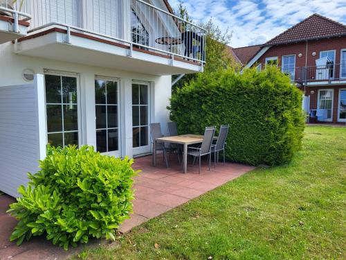a patio with a table and chairs in a yard at Rügen Träume in Sagard