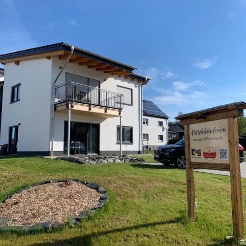 une maison avec un panneau devant dans l'établissement Im Blauen Ländchen, à Lierschied