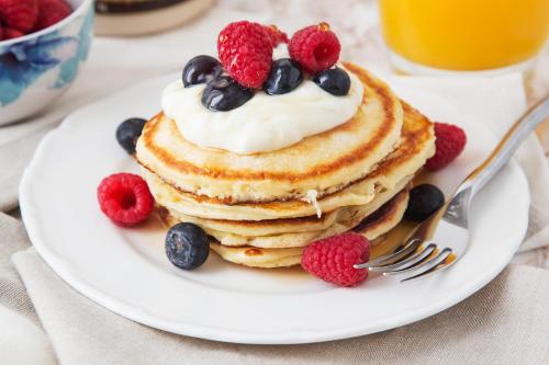 a plate of pancakes with berries and whipped cream at Titanic Guest 4 Star Boutique- Tourism NI certified- Free parking in Belfast