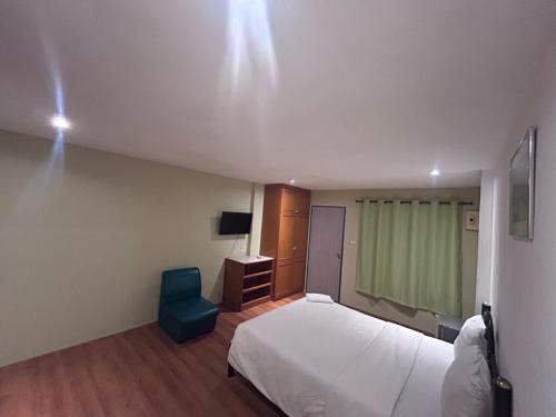 a bedroom with a bed and a blue chair at Green Paradise in Pattaya North