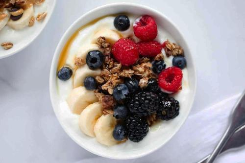 a bowl of yogurt with fruit and granola at Titanic Guest 4 Star Boutique- Tourism NI certified- Free parking in Belfast