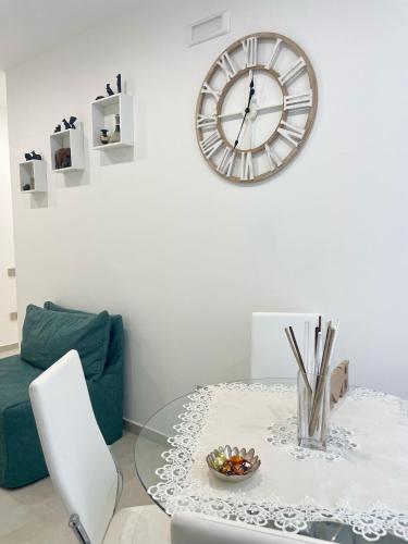 a living room with a table and a clock on the wall at Dream Suite Bologna in Bologna