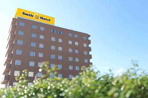 a building with a hotel sign on top of it at スマイルホテルさくらんぼ東根 in Higashine
