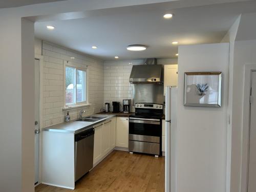 a kitchen with a sink and a stove top oven at Serenity Charm - Walk in Town, Shaw, Hottub in Niagara on the Lake