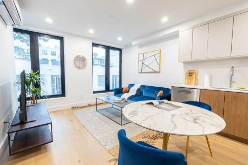 a living room with a blue couch and a table at 202 New Condo 1BR in Prime Greenpoint in Brooklyn