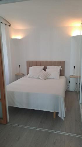 - un lit blanc avec des oreillers blancs dans une chambre dans l'établissement Appartement centre ville cannes, à Cannes