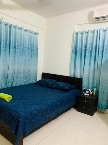 a bedroom with a blue bed with blue curtains at Modern Furnished Apartment in Uttara Near Metro in Dhaka