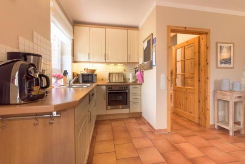 una cocina con fregadero y estufa en Landhaus, en Kellenhusen