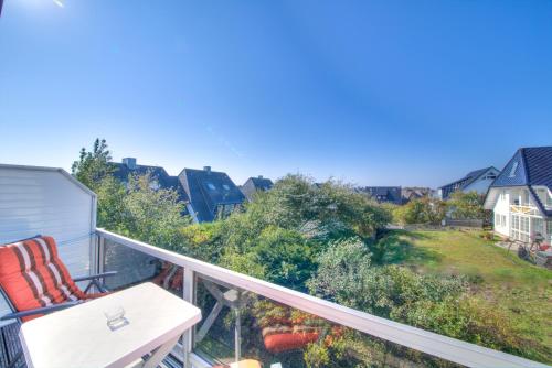 a balcony with a chair and a view of a yard at Windeby 5D in Wenningstedt
