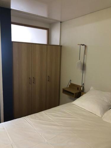 une chambre avec un lit et une armoire en bois dans l'établissement Brise marine - climatisation - les pieds dans l'eau, à Sète