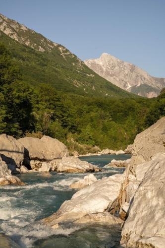 a river with rocks and mountains in the background at Nomad 27 in Bovec