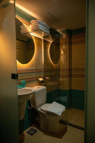 a bathroom with a toilet and a sink and a mirror at Soft Hotel in Cairo