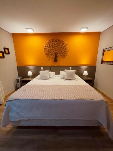 a bedroom with a large bed with yellow walls at Pousada Cantinho da Serra in Campos do Jordão