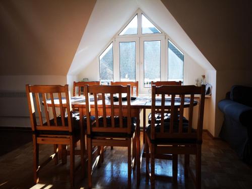 a dining room table with chairs and a large window at Harmonie in Prerow