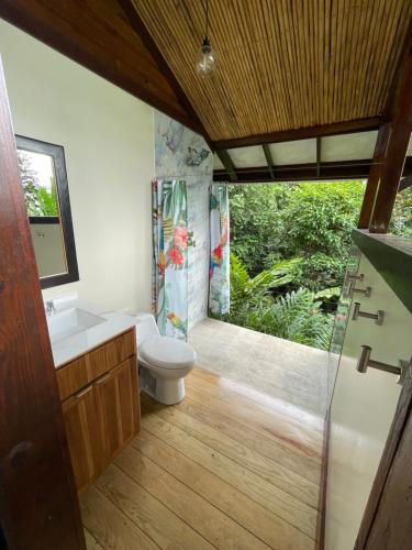 a bathroom with a toilet and a sink and a shower at La Tierra Del Encanto in Bocas del Toro