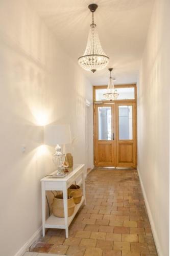 a hallway with a white table and a chandelier at Apartment No1 in Stralsund
