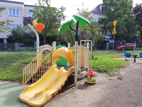 a playground with a slide in a park at Saltwater Apartment Gdynia in Gdynia