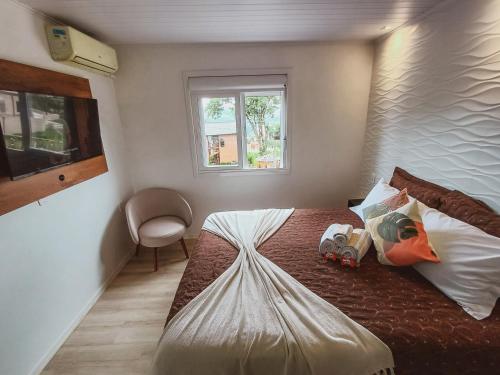 a bedroom with a bed and a window at Pousada Bella Vista - no coração do Vale dos Vinhedos in Bento Gonçalves