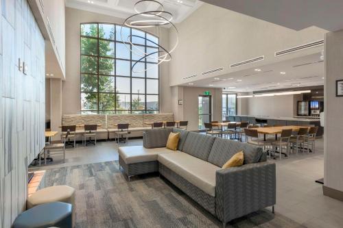 a lobby with a couch and tables and chairs at Executive Residency by Best Western Toronto-Mississauga in Mississauga