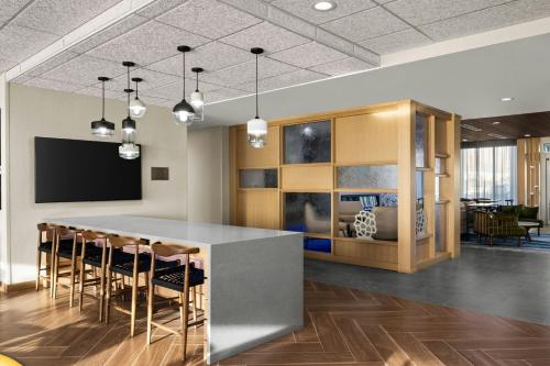 a kitchen with a bar with chairs and a tv at Fairfield Inn & Suites Livermore in Livermore