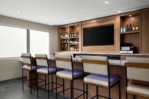 a bar with chairs and a television in a room at Fairfield Inn & Suites Livermore in Livermore
