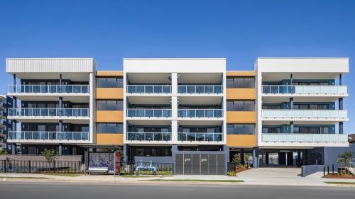 an apartment building with yellow and white balconies at The Arthur Apartments in Coffs Harbour
