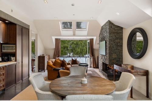 a living room with a table and a fireplace at Ben Lomond 2 -Top-floor lakeshore apartment in Queenstown