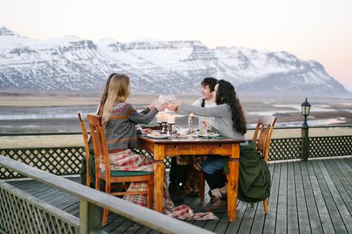 a group of people sitting at a table with wine glasses at Eyjar Fishing Lodge in Breiðdalsvík