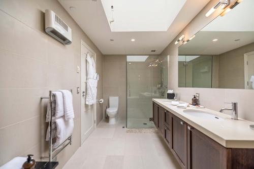 a bathroom with a sink and a toilet and a mirror at Creighton 1 Lake & Mountain View Apt in Queenstown