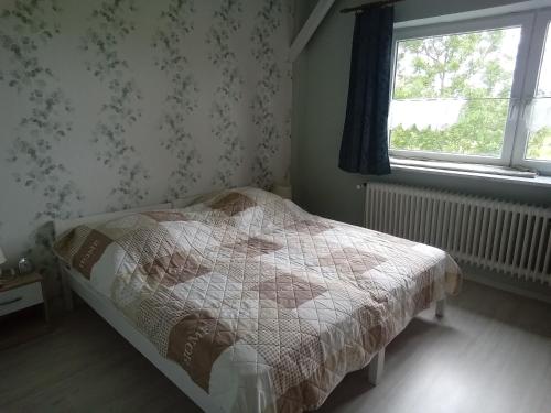 a small bedroom with a bed and a window at Ferienwohnung Wremen in Wremerbüttel