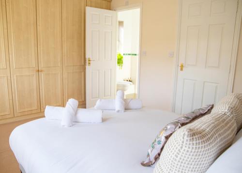 two white beds in a room with a window at 4x Bed Elegant Home with Parking in Ely