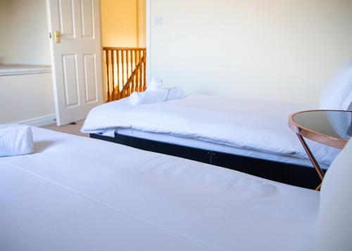 a room with two beds and a table at 4x Bed Elegant Home with Parking in Ely