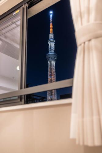 a view of the eiffel tower from a window at Cloud Nine Apartment Sky Tree in Tokyo