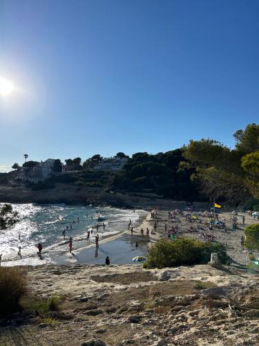 a group of people on a beach in the water at Beach Front 2 Bedrooms Apartment in Torredembarra
