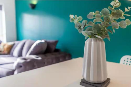 a white vase with a plant on a table at The Woodlands 3bed 2bath in Langley Park