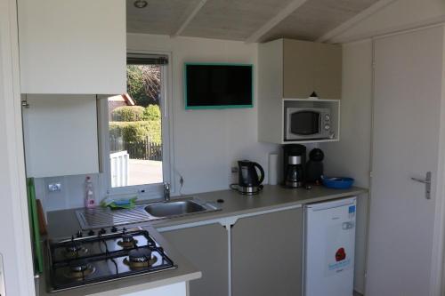 Η κουζίνα ή μικρή κουζίνα στο Mobilheim Herzmuschel mit Veranda am Kransburger See 554