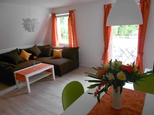 a living room with a couch and a table at Ferienwohnung Haus Glückauf in Kölpinsee