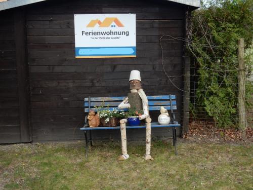 a teddy bear sitting on a bench in front of a sign at Ferienwohnung in der "Perle der Lausitz" in Spremberg