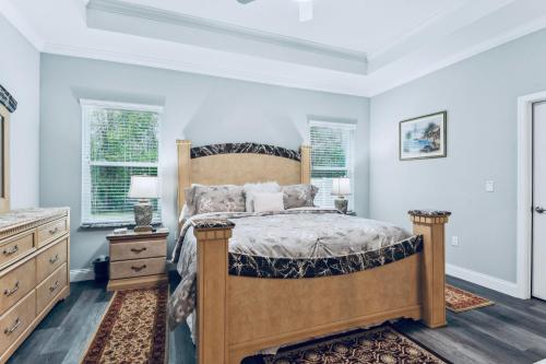 a bedroom with a bed and a dresser and two windows at Spectacular NEW Home With Lots of parking Exit 284 in Palm Coast