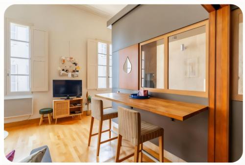 a kitchen with a table and chairs and a television at L' Appart du Centre Historique Charme et confort in Arles