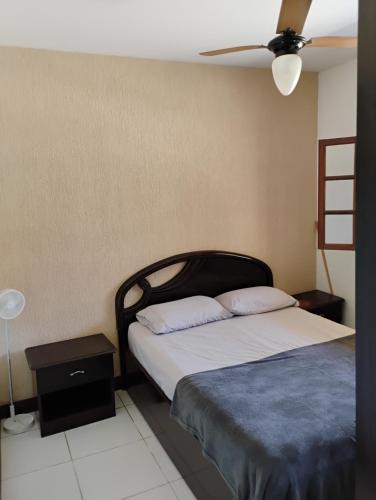 a bedroom with a bed and a ceiling fan at Casa em Búzios in Búzios